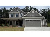 Charming two-story home with a covered porch and a two-car garage in a wooded community at 1211 Cherry Bark Ct, Loganville, GA 30052