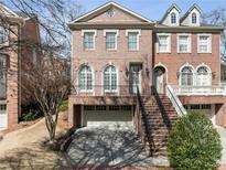 Stunning brick townhouse showcasing a grand entrance with a two-car garage and meticulous landscaping at 612 Timm Valley Ne Rd # A, Atlanta, GA 30305