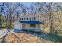 Charming two-story home with a covered front porch and a well-manicured front yard at 169 Holly Ct, Loganville, GA 30052
