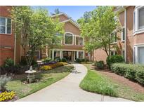 Inviting exterior with lovely landscaping, flowers and a sidewalk leading to a warmly colored condo building at 5300 Brooke Ridge Dr, Atlanta, GA 30338