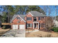 Charming two-story brick home with a two-car garage and well-manicured landscaping at 672 Red Sunset Cir, Powder Springs, GA 30127