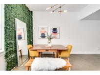 Bright dining area featuring a wood table, yellow chairs, a bench with a white furry cover, and unique wall decor at 680 Greenwood Ne Ave # 202, Atlanta, GA 30306