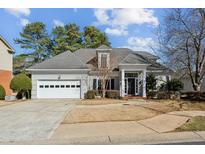 Charming single-Gathering home with a manicured lawn, a two-car garage, and classic architectural details at 1090 Brockton Close, Marietta, GA 30068
