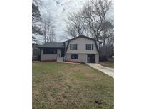 Charming two-story home with a freshly landscaped yard, brick accents, and a newly paved driveway at 7576 Shadow Wood Dr, Jonesboro, GA 30236