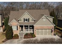 Charming brick home with a covered front porch and a two-car garage, nestled among mature trees at 2131 Independence Ln, Buford, GA 30519