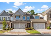Charming townhome featuring brick accents, a two-car garage, and manicured landscaping at 4129 Avid Park, Marietta, GA 30062