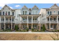Charming townhome exterior featuring a brick foundation, double porches, and stylish architectural details at 1004 Baldwin Dr, Milton, GA 30009
