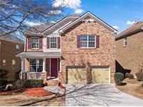 Charming brick home featuring a two-car garage, a covered front porch and manicured landscaping at 5912 Sharp Se Dr, Mableton, GA 30126