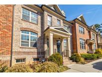 Charming brick townhome featuring a covered entry, manicured landscaping, and classic architectural details at 1216 Lavista Ne Cir, Atlanta, GA 30324