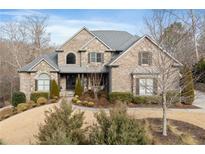 Beautiful brick and stone home with manicured front lawn and mature landscaping at 1355 Cashiers Way, Roswell, GA 30075