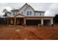 An in-progress white two-story house with an attached three car garage at 4815 Briscoe Dr, Cumming, GA 30028