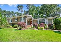 Charming home boasts a well-manicured lawn and lush landscaping, enhancing its curb appeal at 4365 Huntington Cir, Atlanta, GA 30338