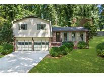 Charming home with a two-car garage, brick and siding accents, and landscaped front yard at 4883 Rock Haven Dr, Lilburn, GA 30047