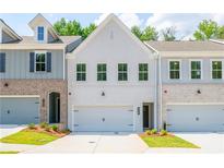 Charming townhome with a white brick facade, front yard, and attached garage at 167 Bluffington Way, Marietta, GA 30066