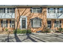Brick townhouse featuring two stories, multiple windows, and a front door entrance at 6520 Roswell Rd # 79, Sandy Springs, GA 30328
