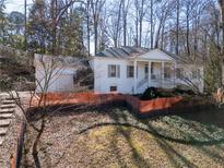 Charming white home featuring a well-manicured lawn and mature trees at 2561 Red Valley Nw Rd, Atlanta, GA 30305