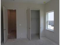 A bedroom features natural light from a window and an open closet at 4780 Briscoe Dr, Cumming, GA 30028