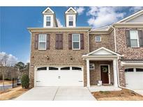 Charming brick townhome with a two-car garage and a cozy entrance, enhanced by decorative shutters and dormer windows at 222 Ellis Ln, Woodstock, GA 30189