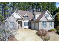 Charming brick home featuring a two-car garage, mature landscaping, and a welcoming front entrance at 76 Misty View Ln, Acworth, GA 30101