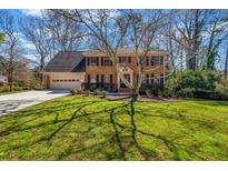 Charming brick home featuring a well-maintained lawn, attached garage, and mature trees in a desirable neighborhood at 3736 Bloxham Ct, Atlanta, GA 30341