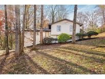 Charming home with a beautiful brick and siding exterior, surrounded by mature trees and natural landscaping at 3306 Sleepy Se Ln, Smyrna, GA 30080