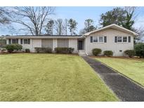 Charming single-story brick home with a well-manicured lawn and inviting walkway at 1385 Lucky Sw Ln, Mableton, GA 30126