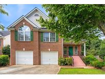 Charming brick home with two-car garage, green shutters, and front yard landscaping at 4515 Parkview Walk Dr, Lilburn, GA 30047