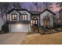 Charming two-story home with a two car garage, landscaped yard, and striking black and white trim at 910 Litchfield Pl, Roswell, GA 30076