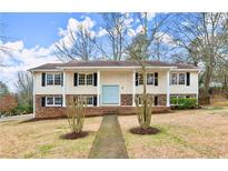 Charming two-story home with a light blue door, black shutters, and a well-manicured front yard at 3284 Devaughn Ne Dr, Marietta, GA 30066