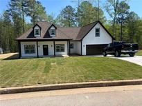 Charming new construction home with a manicured lawn, modern white siding and black trim at 200 Brookwood Xing, Douglasville, GA 30134