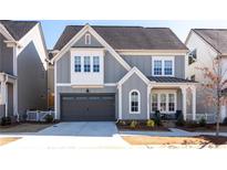 Charming two-story home featuring a gray exterior, a two-car garage, and a welcoming front porch at 2008 Cottonwood Ln, Woodstock, GA 30188