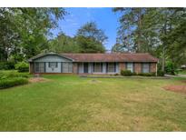 Charming single-story home featuring a well-maintained lawn and mature trees at 3319 Colony Dr, Conyers, GA 30013