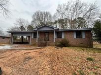 Charming brick home with an attached carport and welcoming front entrance with a small front yard at 3450 Estes Dr, Atlanta, GA 30349