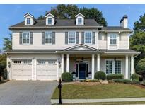 Charming home with a manicured front lawn, three-car garage, and classic architectural details at 200 Edinburgh Ln, Woodstock, GA 30188
