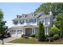 Charming two-story home features a manicured lawn, a three car garage and mature trees at 200 Edinburgh Ln, Woodstock, GA 30188