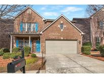 Charming brick home with a two-car garage, bright blue door, well-kept landscaping, and stylish blue window shutters at 3455 Flycatcher Way, Duluth, GA 30097