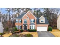 Charming two-story brick home with a well-maintained lawn and mature trees at 506 Old Field Cv, Woodstock, GA 30189