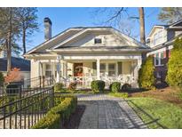 Charming home featuring a quaint front porch, manicured landscaping, and a brick walkway at 126 Ridgeland Ne Way, Atlanta, GA 30305