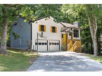 Charming home featuring a two-car garage and a basketball hoop on a tree-lined lot at 2557 Wagon Wheel Trce, Duluth, GA 30096