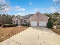 Charming, single-story brick home boasts a well-manicured lawn and two-car garage, offering comfort and curb appeal at 2503 Owens Landing Nw Trl, Kennesaw, GA 30152