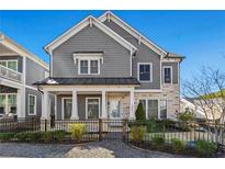 Charming two-story home featuring a mix of stone and siding with a well-manicured front yard and black metal fence at 1961 Haley Walk, Atlanta, GA 30318