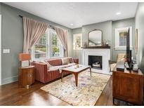Cozy living room with a decorative fireplace, plush sofa, and hardwood floors at 427 S Columbia Dr, Decatur, GA 30030
