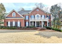 Beautiful brick home featuring manicured landscaping and a stately front porch with classic architectural details at 3001 Prestwyck Haven Dr, Duluth, GA 30097