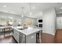 Bright, modern kitchen features stainless appliances, pendant lighting, and a spacious island overlooking the living area at 1872 Commons Nw Pl, Atlanta, GA 30318