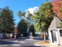 Elegant gated entrance with a water fountain feature surrounded by lush greenery and mature trees at 2201 Pine Heights Ne Dr, Atlanta, GA 30324