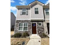 Charming townhome featuring stone accents and neutral siding with well-maintained landscaping at 807 Ambient Sw Way, Atlanta, GA 30331