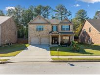 Charming two-story brick home with a well-manicured lawn, two-car garage and inviting front porch at 1118 Reddy Farm Rd, Grayson, GA 30017