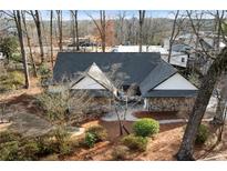 Charming home featuring stone accents, a dark gray roof, and mature trees in a wooded setting at 501 Brook Hollow Se Cir, Marietta, GA 30067