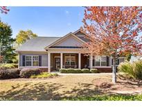 Charming single-story home featuring a covered front porch, well-maintained lawn, and mature trees at 1350 Bluestone Dr, Cumming, GA 30041