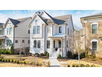 Charming two-story home with white siding, black framed windows and a well-manicured front yard in a desirable neighborhood at 720 Tannery Cmn, Alpharetta, GA 30009